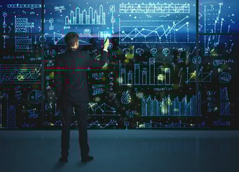 Businessman drawing business statistics on glass wall